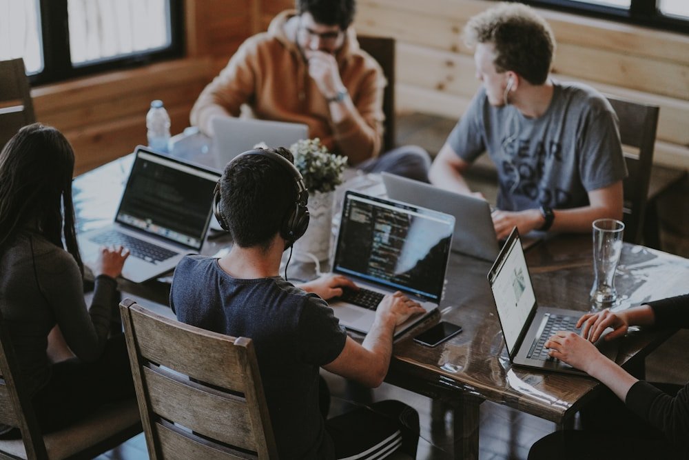A team collaborating around laptops in a shared workspace